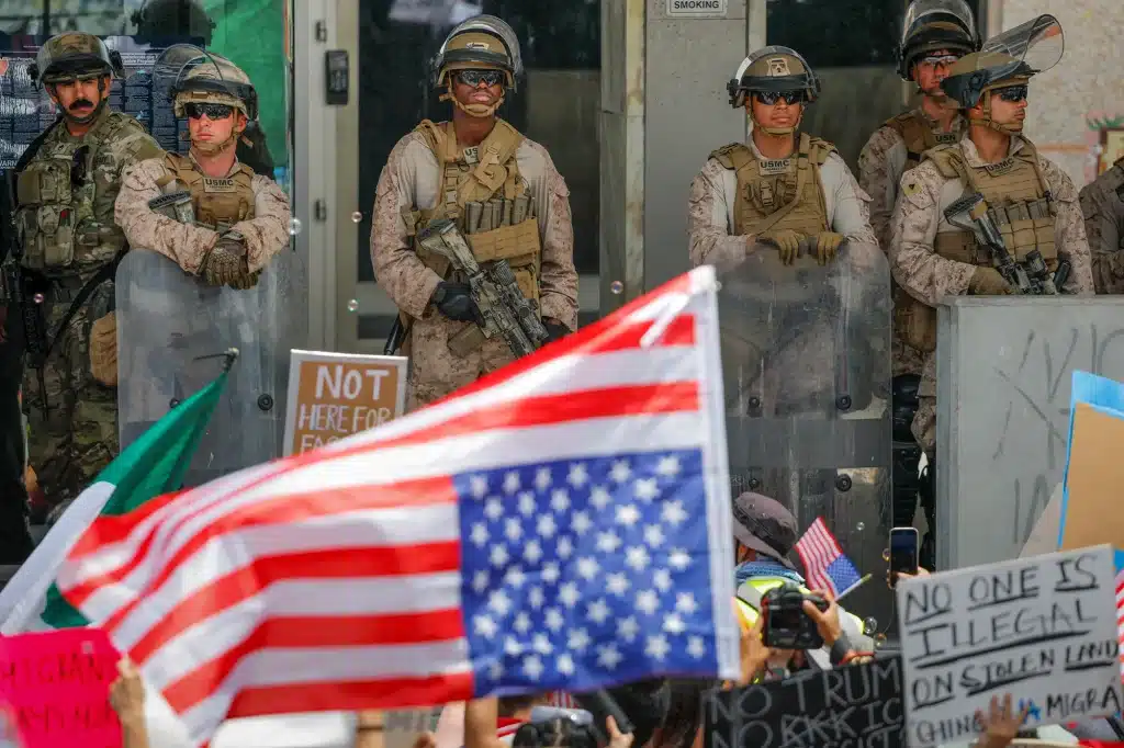Demonstrators wave U.S. and Mexican flags as U.S. Marines stand guard outside the Edward R. Roybal Federal Building during a No Kings Day protest against President Donald Trump's policies in Los Angeles, on June 14, 2025. Photo by Mike Blake, Reuters