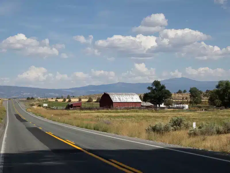 Barn on the side of the road with a field